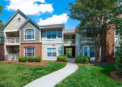 Thumbnail 28 of 36 - Meticulously maintained grounds with mature trees surround the soft green paint and brick exterior apartment homes at Autumn Park Apartments, Charlotte, NC 28262
