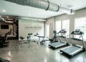 Thumbnail 15 of 21 - a row of cardio machines in a gym at Lakeland Town Square Apartments, Lakeland, TN