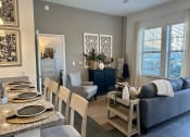 Thumbnail 2 of 21 - a living room and dining room with a blue couch and a table