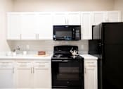Thumbnail 3 of 31 - Cabinetry and Black Appliances in Kitchen at Polos at Hudson Corners Apartments, South Carolina 29650