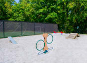 Thumbnail 19 of 36 - a playground with two tennis rackets and two kids playing in the background  at Grove Point, Georgia, 30093