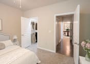 Thumbnail 13 of 51 - A bedroom with a large bed and a hallway leading to another room.