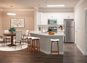 Thumbnail 8 of 51 - A kitchen with a table and chairs and a fridge.
