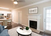 Thumbnail 10 of 51 - A living room with a fireplace and a painting on the wall.