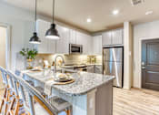 Thumbnail 2 of 38 - a kitchen with a marble counter top and a stainless steel refrigerator at The Beck at Hidden River, Florida