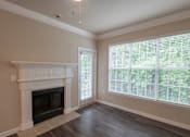 Thumbnail 12 of 51 - A room with a fireplace and a window with blinds.