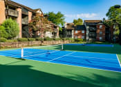 Thumbnail 10 of 16 - two tennis courts with apartments in the background at The Edge of Germantown, Memphis, TN