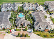 Thumbnail 16 of 16 - A bird's eye view of a residential area with houses and a swimming pool at The Fenwick Apartments, Humble, TX