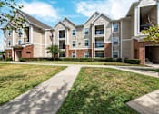 Thumbnail 15 of 16 - Apartment complex with a walkway in front at The Fenwick Apartments, Humble, 77396