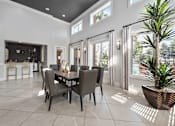 Thumbnail 8 of 16 - A dining room with a table set for six with a plant in a pot on the floor at The Fenwick Apartments, Humble, 77396