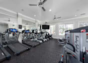 Thumbnail 10 of 16 - A gym with treadmills and exercise equipment at The Fenwick Apartments, Humble