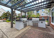 Thumbnail 12 of 16 - A patio with a grill and a pergola at The Fenwick Apartments, Humble
