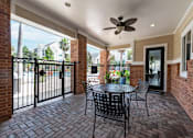 Thumbnail 13 of 16 - A patio with a table and chairs and a ceiling fan at The Fenwick Apartments, Texas 77396