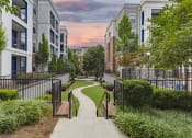 Thumbnail 32 of 33 - a city sidewalk with benches and trees in front of apartment buildings at The Haven, Atlanta