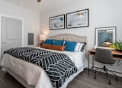 Thumbnail 3 of 15 - A bedroom with a bed, desk, and chair.at The One at Millington, Millington, 38053