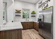 Thumbnail 23 of 33 - A modern kitchen with a marble countertop and wooden cabinets.