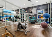 Thumbnail 28 of 33 - A gym with a wooden floor and a variety of exercise equipment.