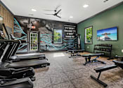 Thumbnail 26 of 33 - A gym with treadmills, benches, and a motivational poster on the wall.