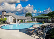 Thumbnail 19 of 28 - A large swimming pool surrounded by lounge chairs and umbrellas.