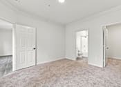 Thumbnail 11 of 34 - A white room with a carpeted floor and two doors.