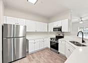 Thumbnail 6 of 34 - A modern kitchen with stainless steel appliances and white cabinets.