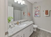 Thumbnail 9 of 27 - a bathroom with a sink and a toilet and a mirror at Twenty35 at Timothy Woods, Athens, GA, 30606