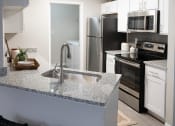 Thumbnail 3 of 27 - an open kitchen with granite counter top and stainless steel appliances at Twenty35 at Timothy Woods, Athens, GA