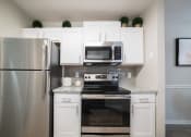 Thumbnail 2 of 27 - a kitchen with stainless steel appliances and white cabinetry at Twenty35 at Timothy Woods, Athens, 30606