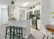 Thumbnail 1 of 27 - an open kitchen and dining area with stools in front of a kitchen counter top at Twenty35 at Timothy Woods, Athens, GA, 30606