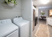 Thumbnail 11 of 27 - a laundry room with two washers and a dryer next to a kitchen with