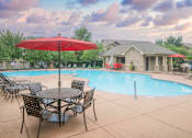 Thumbnail 19 of 26 - A red umbrella is in front of a pool and a house.