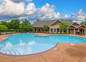 Thumbnail 18 of 26 - A large outdoor swimming pool with a small building behind it.