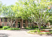 Thumbnail 2 of 30 - A building with a tree in front of it.