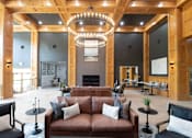 Thumbnail 5 of 30 - A large, open-concept living room with a fireplace and a chandelier.