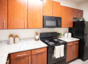 Thumbnail 4 of 20 - Kitchen with Black Appliances at Walden Oaks, Anderson, SC
