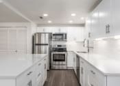 Thumbnail 6 of 34 - Kitchen with stainless steel appliances, white cabinetry, and quartz countertop