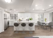Thumbnail 5 of 34 - Kitchen with a kitchen island, hardwod flooring, white cabinetry, and stainless steel appliances