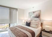 Thumbnail 12 of 42 - A bedroom with a large bed and a painting on the wall.