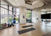 Thumbnail 16 of 42 - A yoga studio with a large window and exercise equipment.