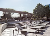 Thumbnail 34 of 42 - A row of sun loungers are arranged on a concrete platform.