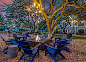 Thumbnail 30 of 30 - A fire pit surrounded by blue chairs in a gravel area.