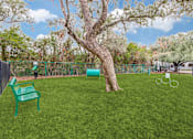 Thumbnail 23 of 30 - A green plastic chair sits on a green lawn.