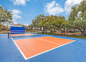 Thumbnail 25 of 30 - A tennis court with blue and orange colors and a net.