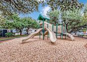 Thumbnail 21 of 30 - A playground with a green roof and a slide.
