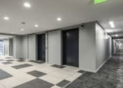 Thumbnail 12 of 16 - Two elevators next to a hallway