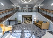 Thumbnail 14 of 16 - Main entrance into lobby area with seating and two large staircases on each side of the room