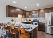 Thumbnail 2 of 16 - Kitchen with dark cabinets, stainless steel appliances and granite countertops