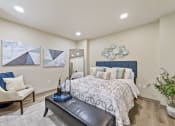 Thumbnail 6 of 25 - a bedroom with a large bed and a chair