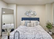 Thumbnail 7 of 25 - a bedroom with white walls and a large bed with a blue headboard