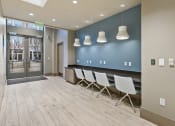 Thumbnail 17 of 25 - a room with a row of white chairs in front of a blue wall and a glass door